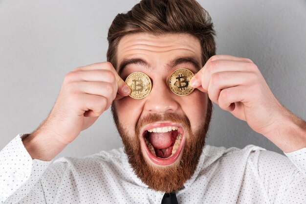 Photo gratuite gros plan d'un homme d'affaires joyeux avec des bitcoins dans les yeux