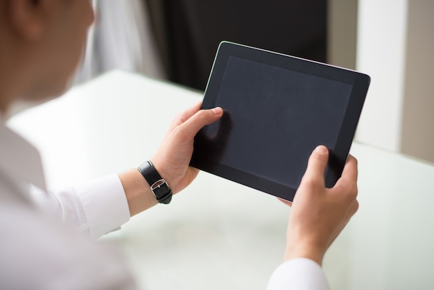 Gros plan d&#39;un homme d&#39;affaires travaillant avec une tablette numérique au bureau