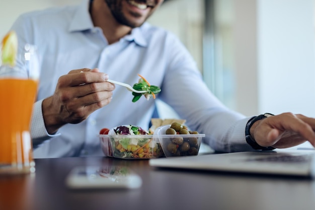 Gros plan sur un homme d'affaires utilisant un ordinateur portable pendant la pause déjeuner