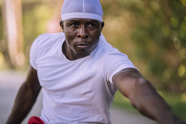 Photo gratuit gros plan d'un homme afro-américain dans une chemise blanche qui s'étend au parc