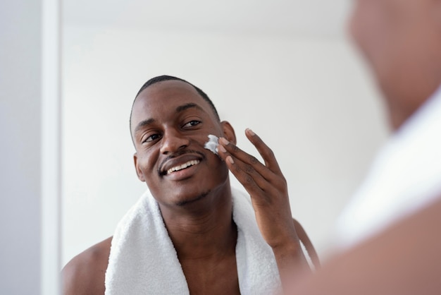 Gros plan homme à l'aide de crème pour le visage