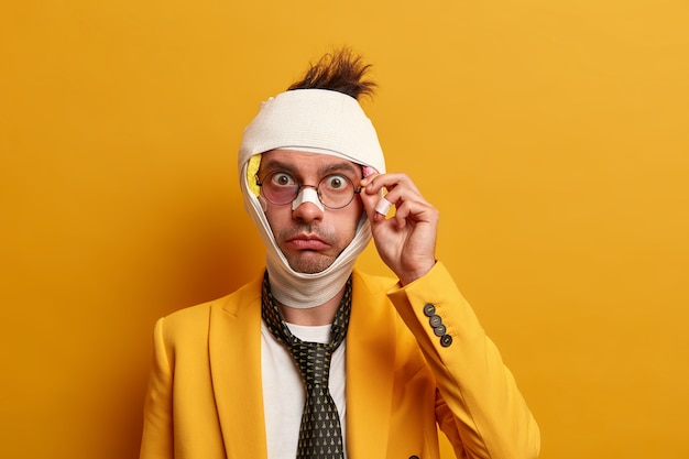 Photo gratuite gros plan sur un homme blessé avec une ecchymose sombre sous les yeux et une commotion cérébrale, porte un bandage