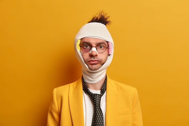 Photo gratuite gros plan sur un homme blessé avec une ecchymose sombre sous les yeux et une commotion cérébrale, porte un bandage