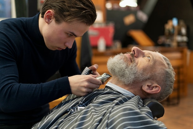 Gros plan sur l'homme et le coiffeur à l'intérieur