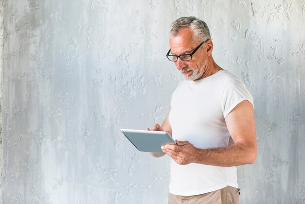 Gros plan, de, homme, debout, devant, béton, mur, utilisation, tablette numérique