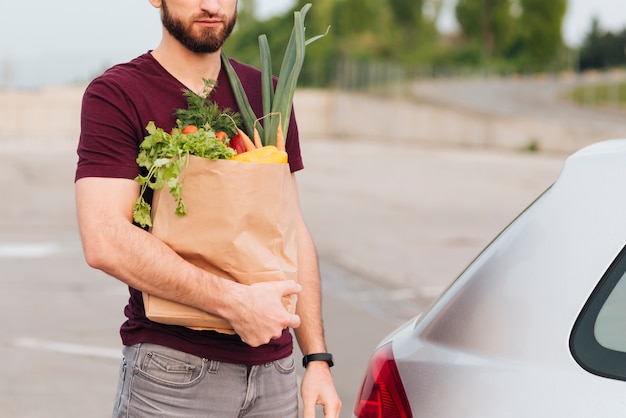 Photo gratuite gros plan homme debout près de la voiture