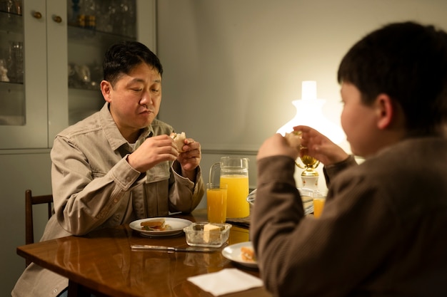 Photo gratuite gros plan homme et enfant assis à table