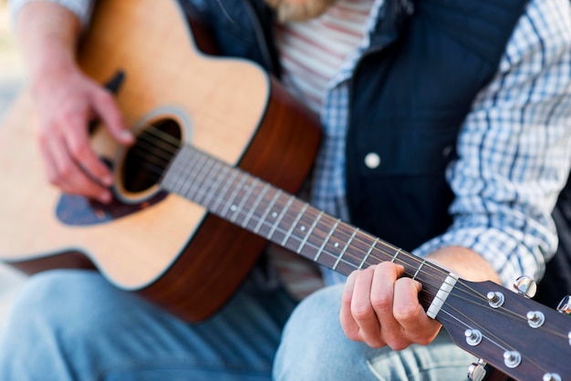 Gros plan, homme, jouer guitare acoustique