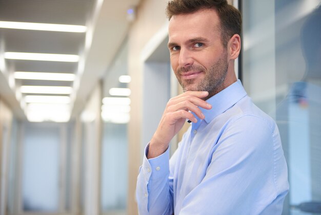 Gros plan sur l'homme réfléchi dans le couloir du bureau