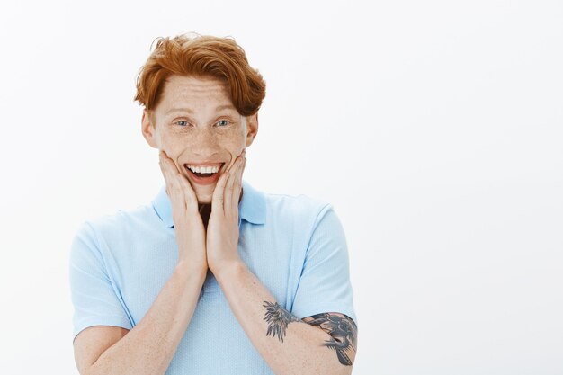 Gros plan d'un homme rousse souriant heureux à la joie, heureux d'entendre quelque chose de bien