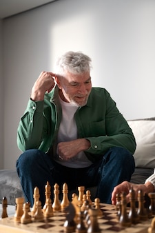 Gros plan homme souriant jouant aux échecs