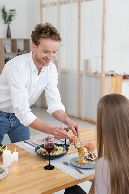 Gros plan homme souriant tenant des couverts