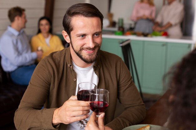 Gros plan homme souriant tenant un verre à vin