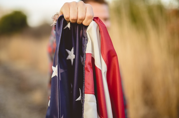 Gros plan d'un homme tenant le drapeau des États-Unis