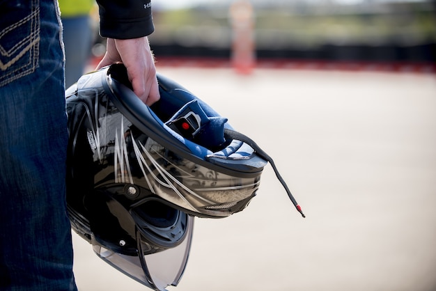 Photo gratuite gros plan d'un homme tenant son casque de moto avec une distance floue