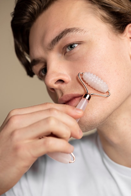 Photo gratuite gros plan homme utilisant l'outil gua sha