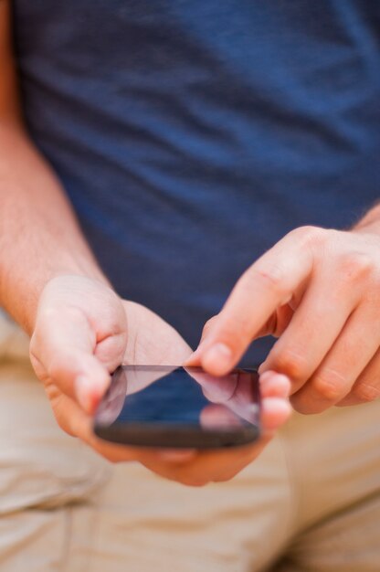 Gros plan d&#39;un homme utilisant un téléphone mobile intelligent