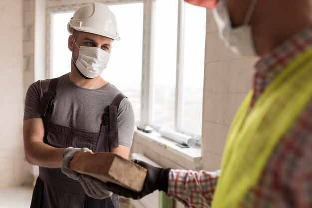 Gros plan des hommes de constructeur travaillant