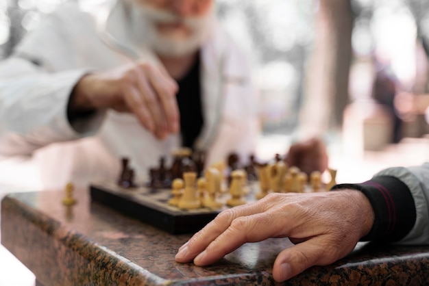 Photo gratuite gros plan des hommes jouant aux échecs à l'extérieur