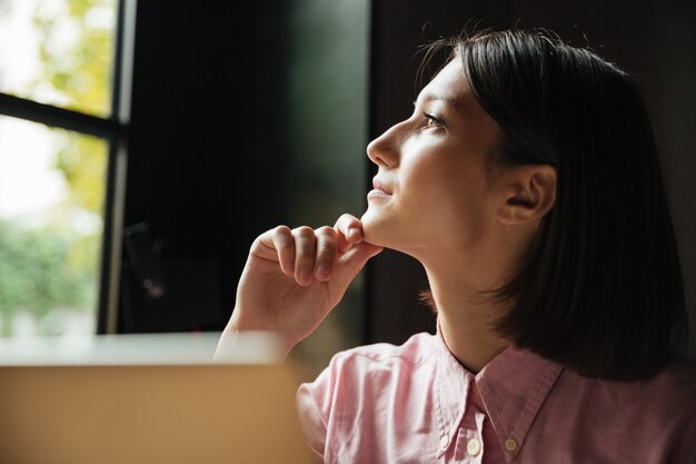 Gros plan image de femme pensive assise près de la table