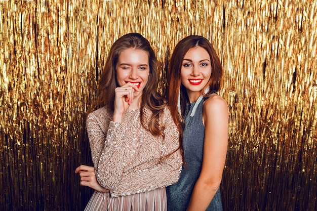 Gros plan image studio de deux incroyables filles célébrant sexy avec des lèvres rouges, visage surprise,