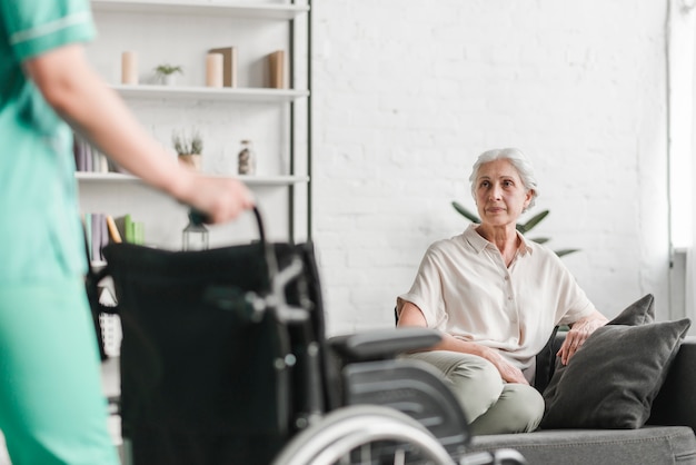 Photo gratuite gros plan, infirmière, tenue, fauteuil roulant, devant, sénior, patient