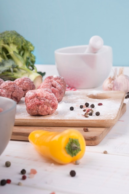 Gros plan des ingrédients et des boulettes de viande sur planche de bois