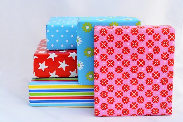Gros plan isolé de coffrets cadeaux dans des emballages colorés empilés sur le dessus et à côté de chaque