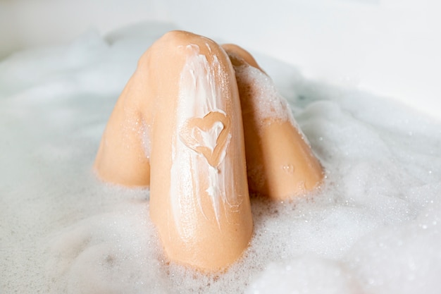 Gros plan, jambes, baignoire, mousse