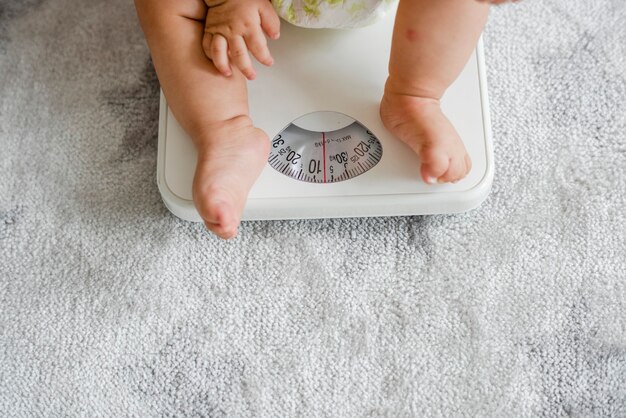 Gros plan des jambes d'un bébé sur une balance