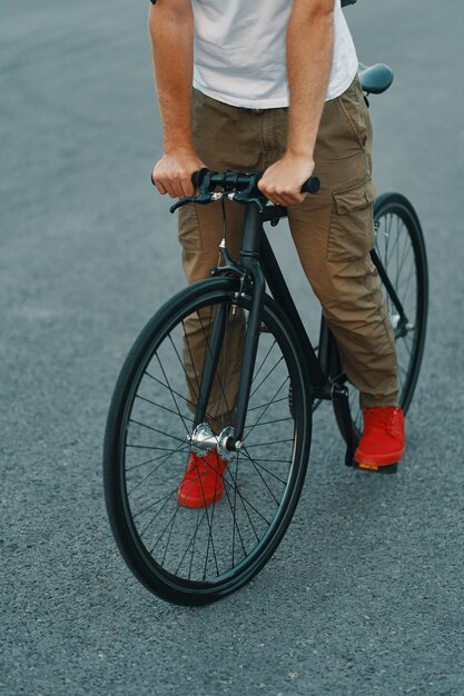 Gros plan des jambes de l'homme décontracté équitation vélo classique sur la route de la ville