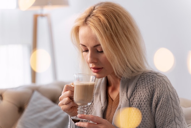 Gros plan sur un jeune adulte appréciant une boisson chaude