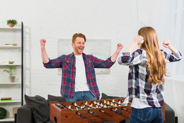 Gros plan, de, jeune couple, célébrer, les, victoire, après, avoir joué, table, soccer