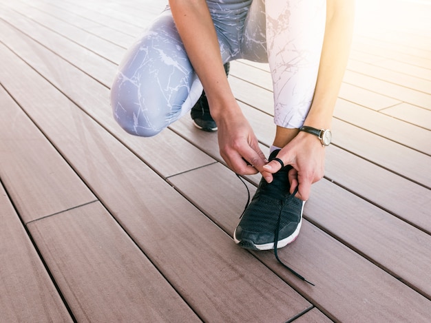 Gros plan, de, jeune femme, attacher, chaussure sport