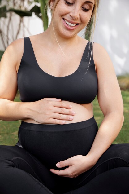 Gros plan sur une jeune femme enceinte faisant du yoga