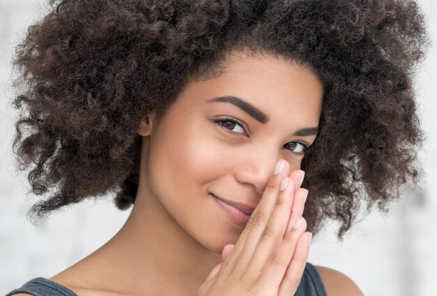 Gros plan d'une jeune femme posant sur un fond blanc