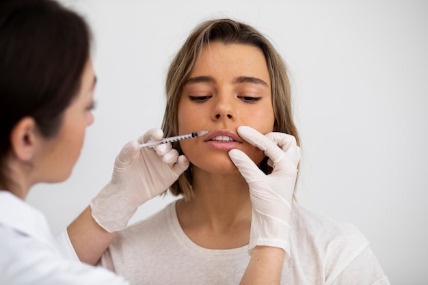 Gros plan jeune femme se remplissant les lèvres