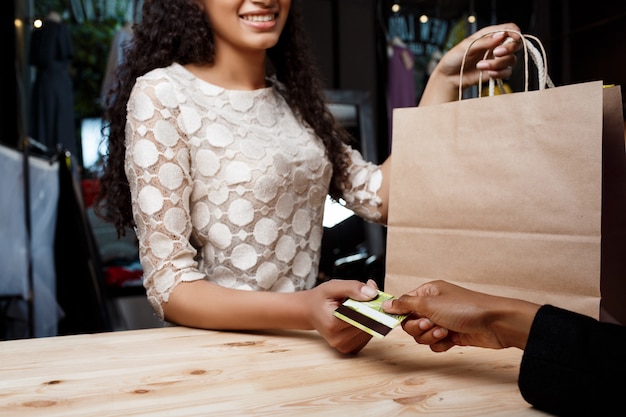 Gros plan de jeune fille payant pour les achats dans le centre commercial.