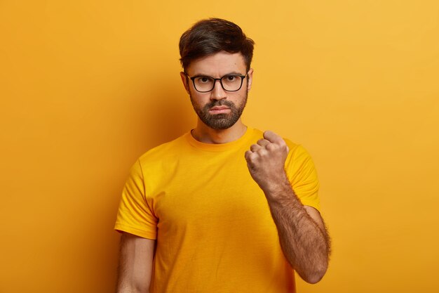Gros plan sur le jeune homme barbu portant des lunettes isolées