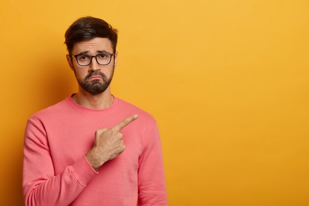 Gros plan sur le jeune homme barbu portant des lunettes isolées