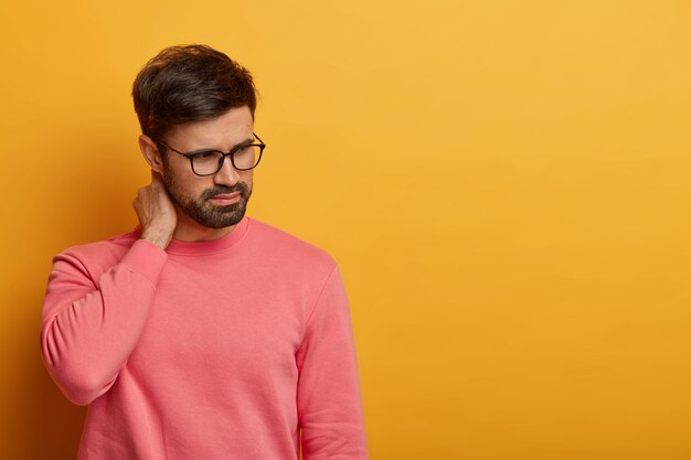 Gros plan sur le jeune homme barbu portant des lunettes isolées