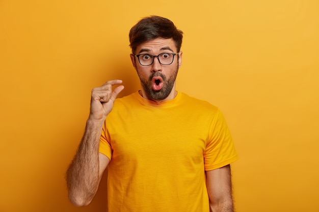 Gros plan sur le jeune homme barbu portant des lunettes isolées