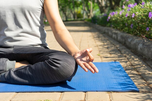 Gros plan de jeune homme méditant dans la pose de lotus et de pratiquer la main mudra à l&#39;extérieur