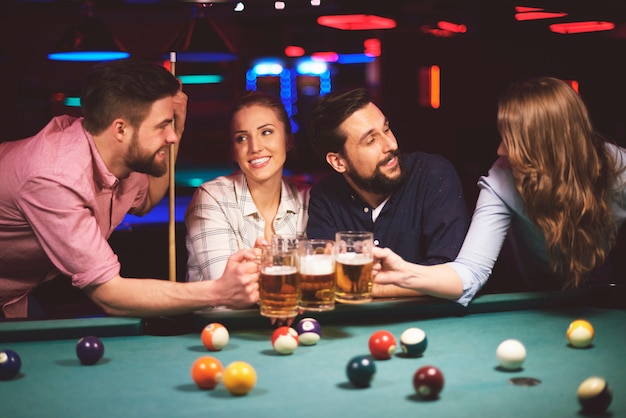 Photo gratuite gros plan sur les jeunes amis s'amusant tout en jouant au jeu de billard