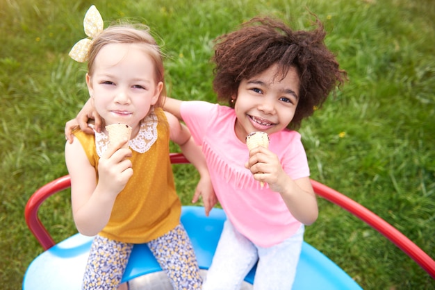 Gros plan sur les jeunes beaux enfants ayant de la crème glacée ensemble