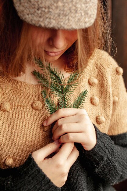 Gros plan jolie fille avec brindille de sapin