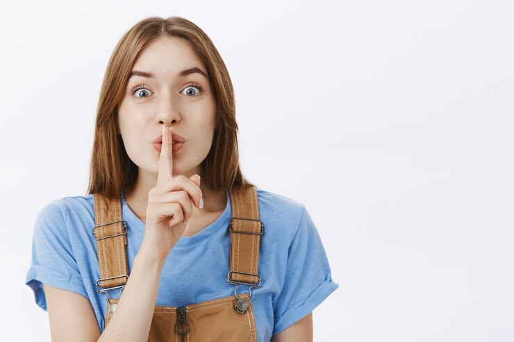 Photo gratuit gros plan d'une jolie fille optimiste shushing, appuyez sur le doigt sur les lèvres, gardez le secret ou préparez la surprise