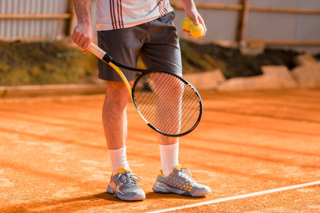 Gros plan d&#39;une joueuse de tennis avec une raquette et une balle