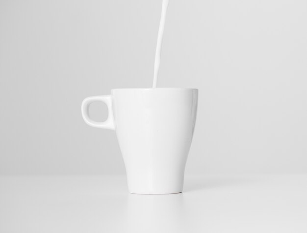 Gros plan, lait, verser, dans, tasse céramique