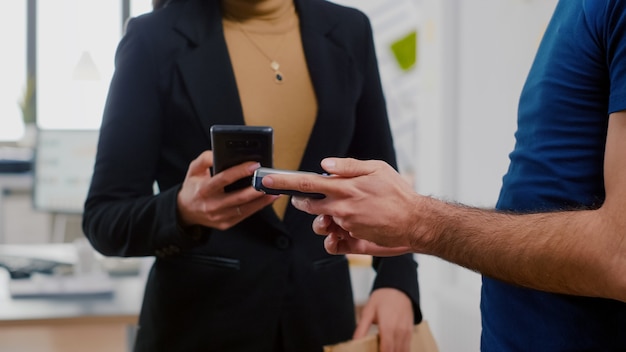 Gros plan d'un livreur tenant un repas à emporter sur le lieu de travail du bureau de l'entreprise pendant l'heure du déjeuner à emporter